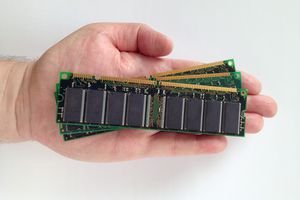Cropped Hand Of Man Holding Random Access Memories Against White Background