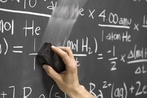 Photo of someone erasing equations written on a chaulkboard