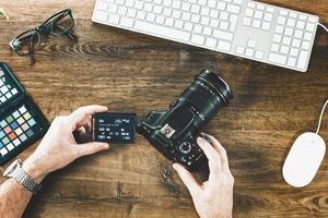 High Angle View Of Man Holding Camera At Table