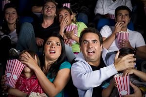 Image of people watching a movie with a scary or inappropriate scene