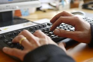 A picture of hands typing on a computer keyboard