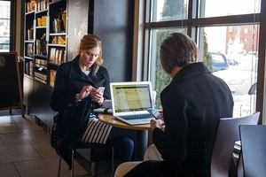 Two women using their devices to message