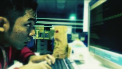Side-view of a hacker-type male using a computer