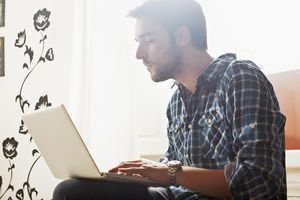 Young man sitting indoor using laptop computer