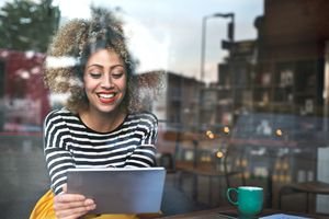Woman using tablet computer in coffee shop