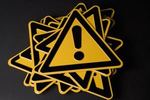 Stack of warning signs that are yellow triangles with exclamation marks on them