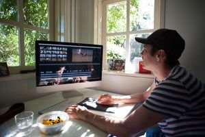 Guy editing video on a Mac computer