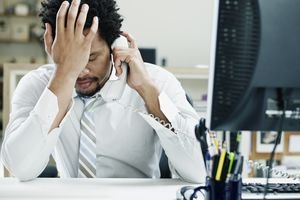 Photo of a businessman on a phone in front of a computer