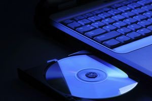 Laptop with open dvd drive in blue light