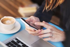 Woman using cell phone at cafe