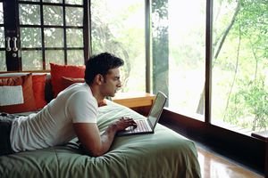 Young man on bed using laptop