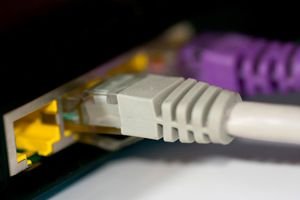 Network and modem cables plugged into a computer modem.