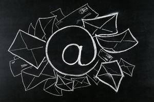 Image of email symbol on a blackboard surrounded by incoming email messages.