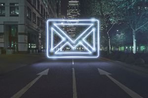 Neon envelope symbol in one way street at night
