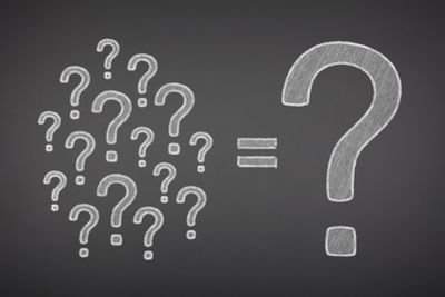 Photo of question marks on a blackboard