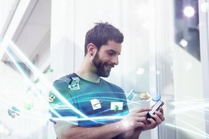 Mid adult man with apps and lights coming from smartphone