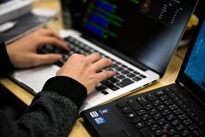 Hands on laptop, alongside another laptop