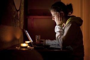 Woman looking at computer in dark room