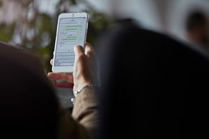 Close-up of man texting with girl friend on phone.